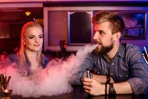 un hombre y mujer de fumar electrónico cigarrillo en un vape bar. foto