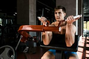 Tense muscles of hands under load. Man doing exercise for biceps in the gym. photo