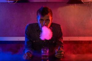 The man smoke an electronic cigarette at the vape shop. photo