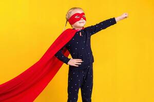 Superhero little girl in a red raincoat and a mask photo