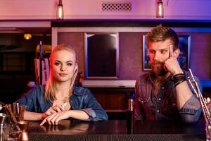 A man and woman smoking electronic cigarette in a vape bar. photo