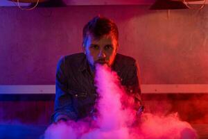 The man smoke an electronic cigarette at the vape shop. photo