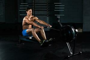Muscular man doing exercise for legs in the gym photo