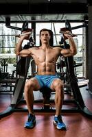 Tense muscles of hands under load. Man doing exercise for biceps in the gym. photo