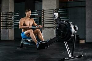 Bodybuilder working on his legs with weight machine at the gym photo