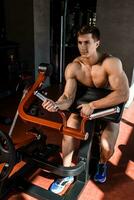 Tense muscles of hands under load. Man doing exercise for biceps in the gym. photo