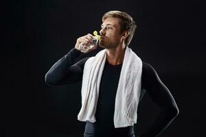 Portrait of a fitness man with towel on shoulders looking away. Happy young man relaxing after training. photo