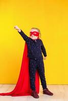Superhero little girl in a red raincoat and a mask photo