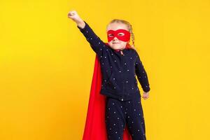 superhéroe pequeño niña en un rojo impermeable y un máscara foto