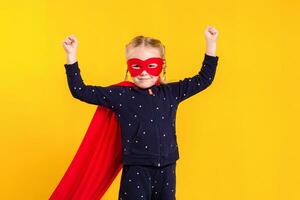 superhéroe pequeño niña en un rojo impermeable y un máscara foto