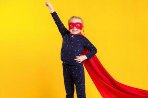 Funny little power superhero child girl in a red raincoat and a mask. Superhero concept. photo