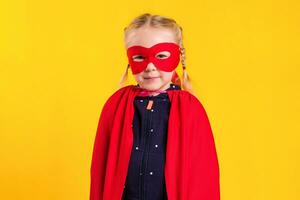 Funny little power superhero child girl in a red raincoat and a mask. Superhero concept. photo
