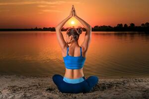 yoga a puesta de sol en el playa. foto