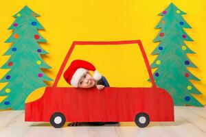 Child in red Christmas car. Xmas holiday concept photo