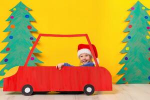 Child in red Christmas car. Xmas holiday concept photo