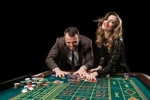 hombre y mujer jugando a ruleta mesa en casino foto