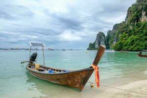 Wooden long tail boat anchored on phi phi island photo