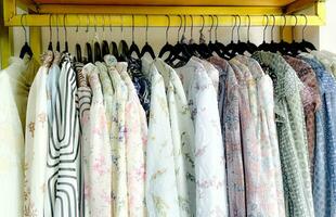 Close-up of color shirts hanging on the rack in fashion store photo