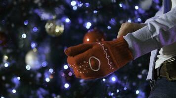 untado fuera mano en rojo de lana guante en Navidad fondo, concepto de alegría en invierno tiempo. hombre vistiendo un Navidad mitón en el mano foto
