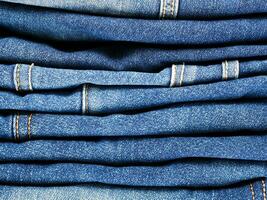 stack of blue jeans background photo