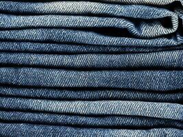 stack of blue jeans background photo