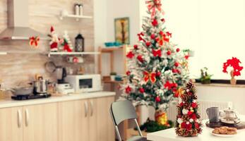 Empty beautiful modern kitchen with delicious cookies for winter holiday. Kitchen on christmas day with nobody in the room decorated with x-mas tree and garlands photo