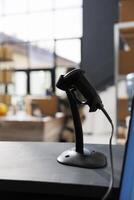 Selective focus of stockroom scanner standing on counter desk in storage room, in background african american worker preparing packages for delivery. Supervisor working at clients online orders photo