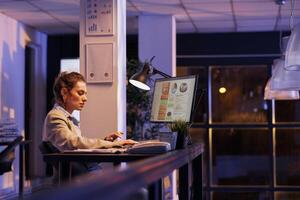 Executive manager working overhours at financial project, analyzing growth report on computer. Businesswoman planning company strategy, developing investment plan to increase profit. Business concept photo