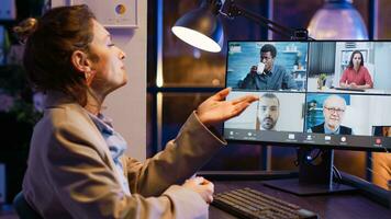 Entrepreneur attending business meeting on video call talking to colleagues about startup investment. Employee using online conference chat late at night, chatting on videoconference. photo