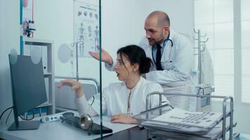 médico personal examinando escanear en ordenador personal, hablando acerca de eso terminado un vaso pared. cuidado de la salud sistema, privado moderno médico hospital clínica foto