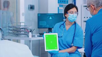 Close up of green screen tablet in modern private hospital or clinic. Isolated mockup chroma replacement screen on gadget for your app, text, video or digital assets. Easy keying medicine medical related theme photo