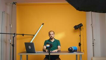 Famous vlogger recording video for subscribers looking at the camera in studio. Social media podcast and review, blogging vlogging, digital internet web era, influencer recording for online distribution photo