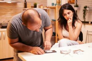 Couple abusing illegal substance in home kitchen. Amphetamine abuse with side effects suffers from pain making seizures, social disaster and narcotics addiction epidemic. photo