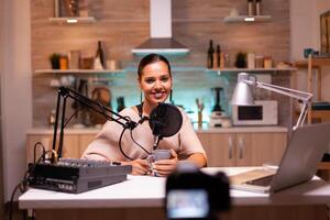 Blogger looking at camera while recording video and speaking on microphone. Online show On-air production internet broadcast host streaming live content, recording digital social media communication photo