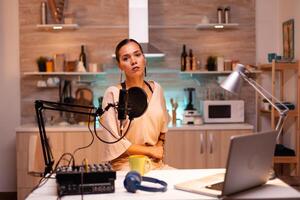 Woman speaking during online show into professional microphone. Creative online show On-air production internet broadcast host streaming live content, recording digital social media communication photo