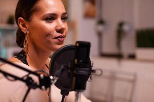 Close up of woman talking on microphone during streaming. On-air online production internet broadcast show host streaming live content, recording digital social media communication photo