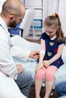 pediatra vendaje niño mano en hospital oficina durante médico examen. cuidado de la salud médico especialista en medicina Proporcionar salud cuidado servicios tratamiento consulta . foto