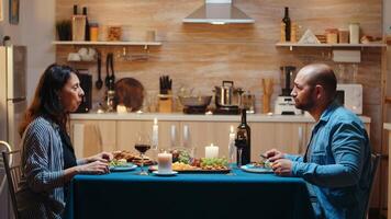 Young happy married couple having video call in kitchen during romantic dinner, eating festive meal. Pov online internet modern conference, chatting, communication, chat conversation call via webcam photo