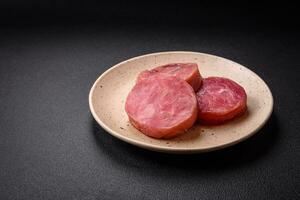 Round shape steaks of raw juicy tuna with salt and spices photo