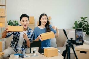 Small business entrepreneur SME freelance Asian man and woman working at home office, BOX, tablet and laptop online, marketing, packaging, delivery. photo