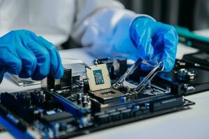 The technician is putting the CPU on the socket of the computer motherboard. electronic engineering electronic repair, electronics photo