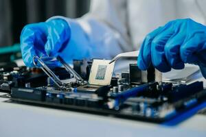 The technician is putting the CPU on the socket of the computer motherboard. electronic engineering electronic repair, electronics photo