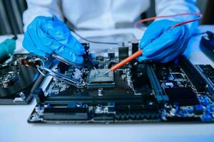 The technician is putting the CPU on the socket of the computer motherboard. electronic engineering electronic repair, electronics photo