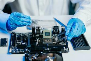 The technician is putting the CPU on the socket of the computer motherboard. electronic engineering electronic repair, electronics photo