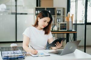 Asian businesswoman working with working notepad, tablet and laptop documents photo