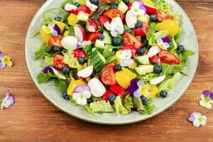 Spring salad with vegetables and flowers. photo