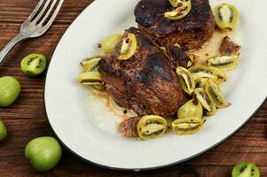 Fried ostrich steak with kiwi sauce photo