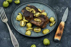 Grilled ostrich steak with kiwi berries photo