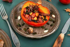 Baked half of pumpkin with fruits and spices. photo