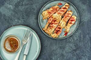 Bacon rolls stuffed with enoki mushroom. photo
